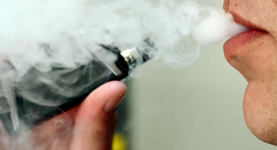 Un hombre exhalando mientras usa un vapeador