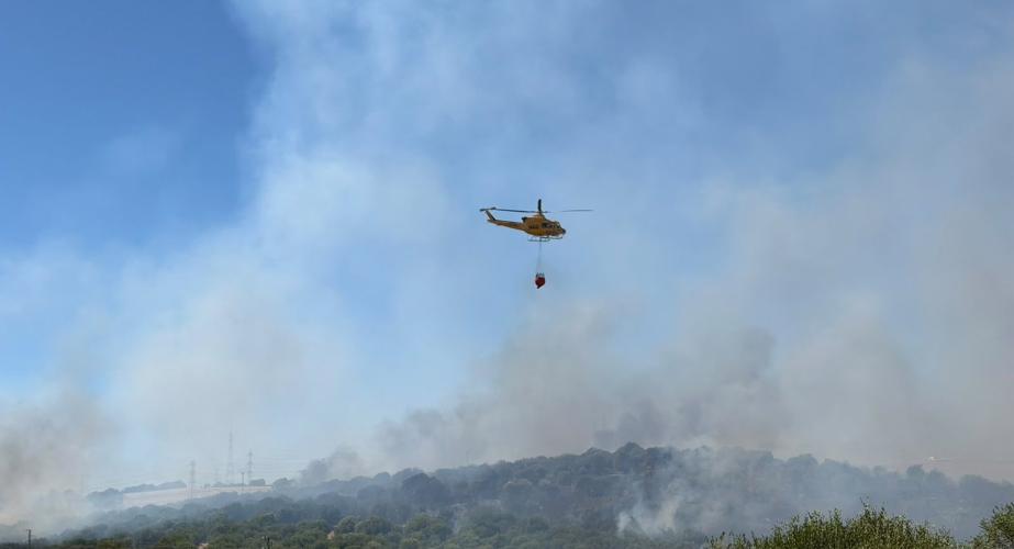 Un helicóptero del Plan Infoca descargando agua sobre el lugar del siniestro
