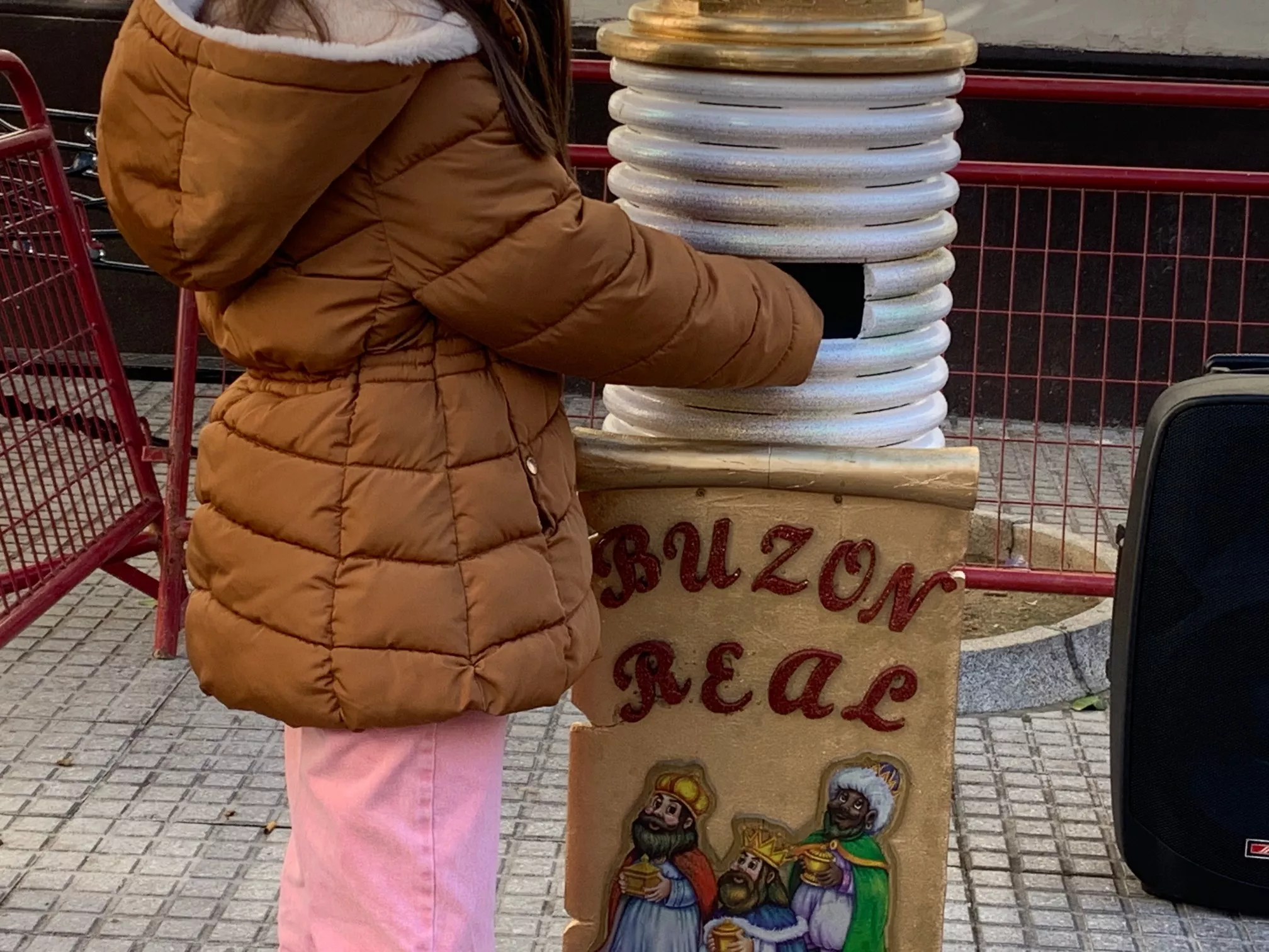 Una niña introduciendo su carta a los Reyes Magos en el buzón situado en la plaza de san Francisco
