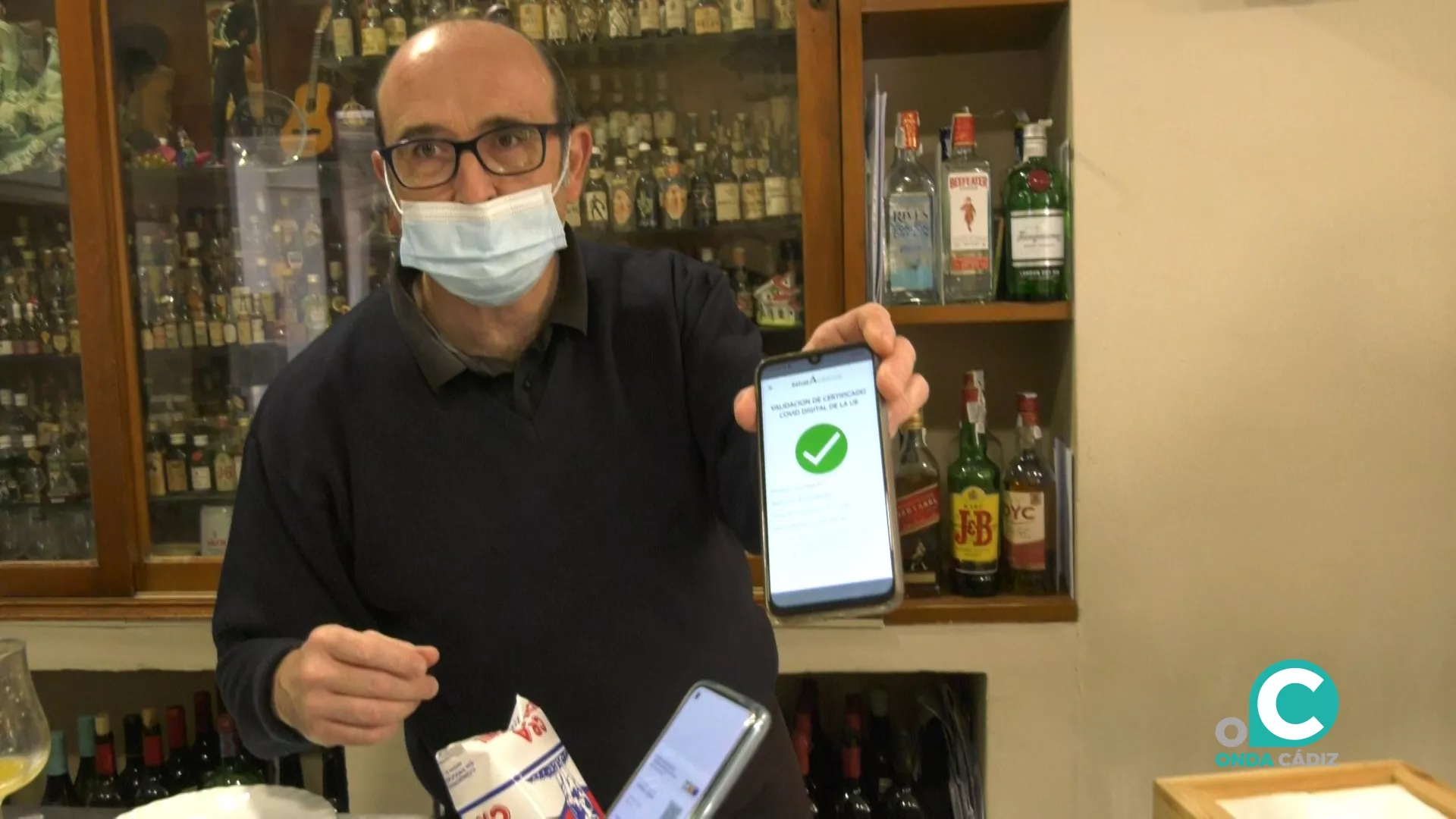 Un trabajador de uno de los bares de la capital muestra el certificado Covid de uno de sus clientes