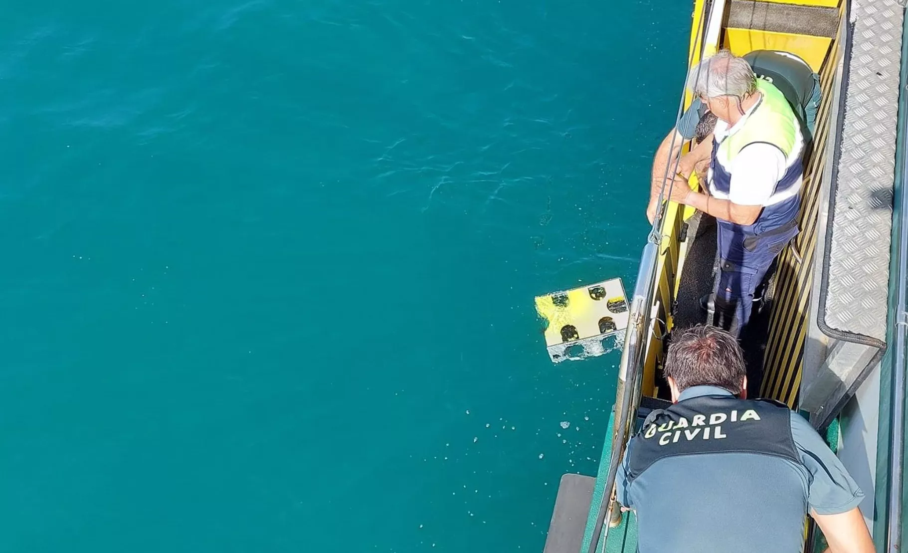 Efectivos del dispositivo de búsqueda sumergiendo un robot subacuático