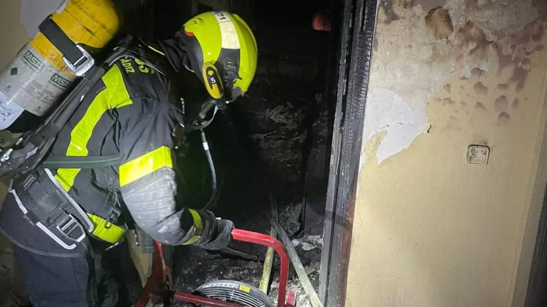 Un efectivo de bomberos sofocando el incendio en la vivienda. 