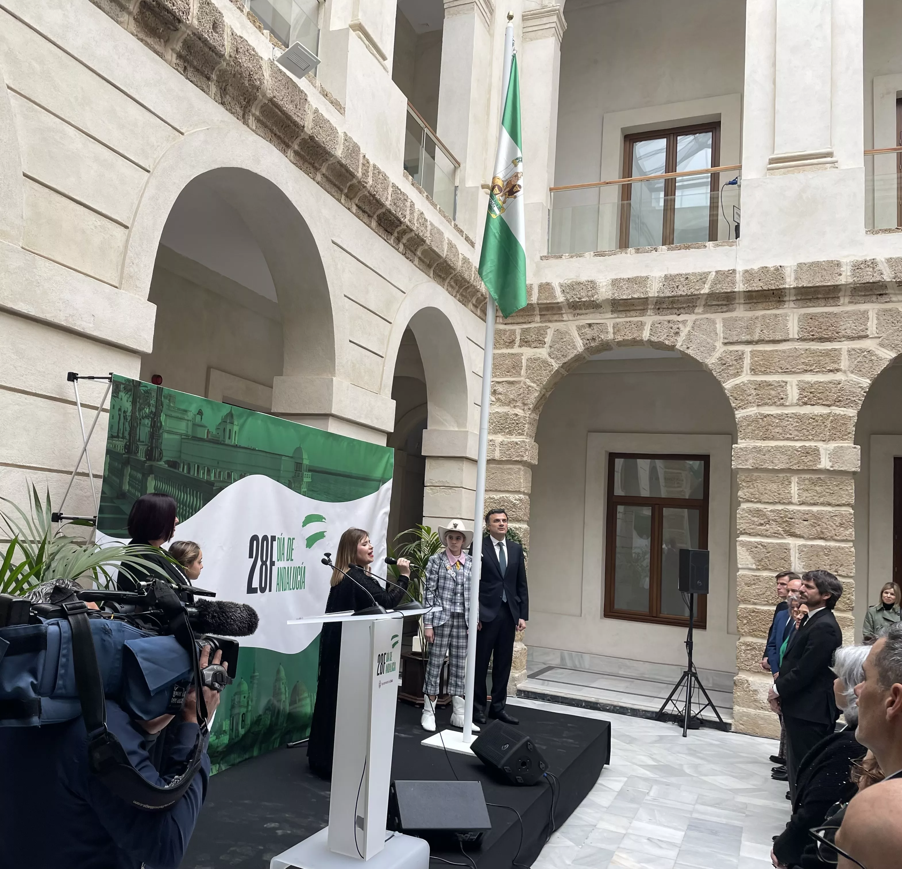 La pregonera infantil y el alcalde de Cádiz izan la bandera de Andalucía en la Casa de Iberoamérica