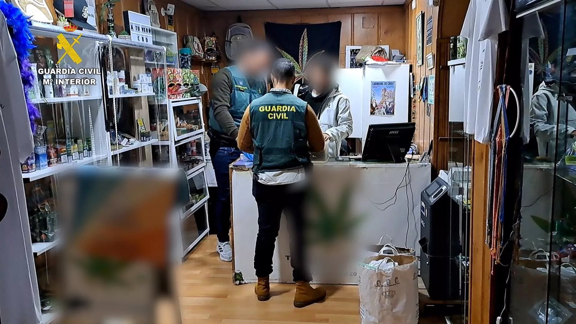 Un agente de la Guardia Civil en uno de los locales de venta de marihuana registrados en una operación en Cádiz