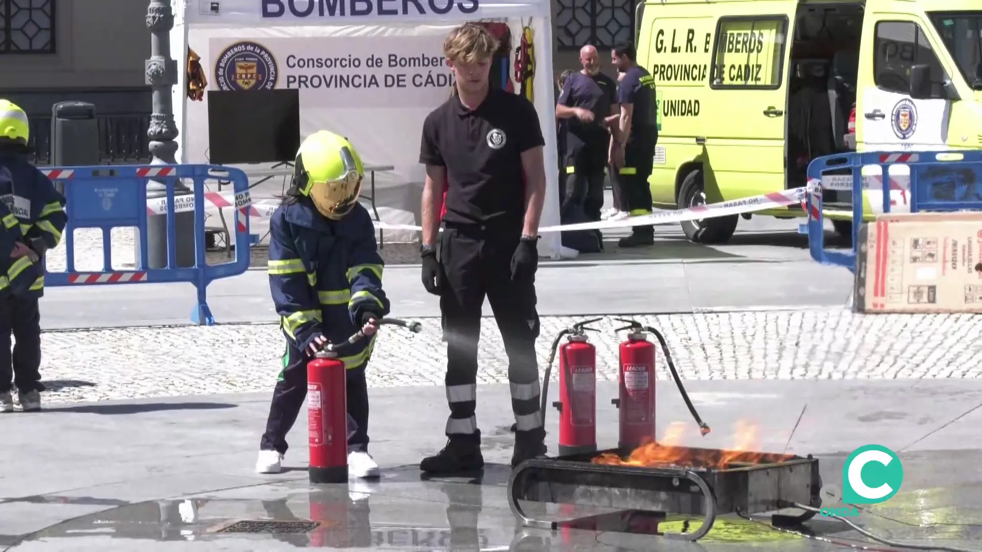 Un escolar participa en una demostración practica para sofocar un fuego