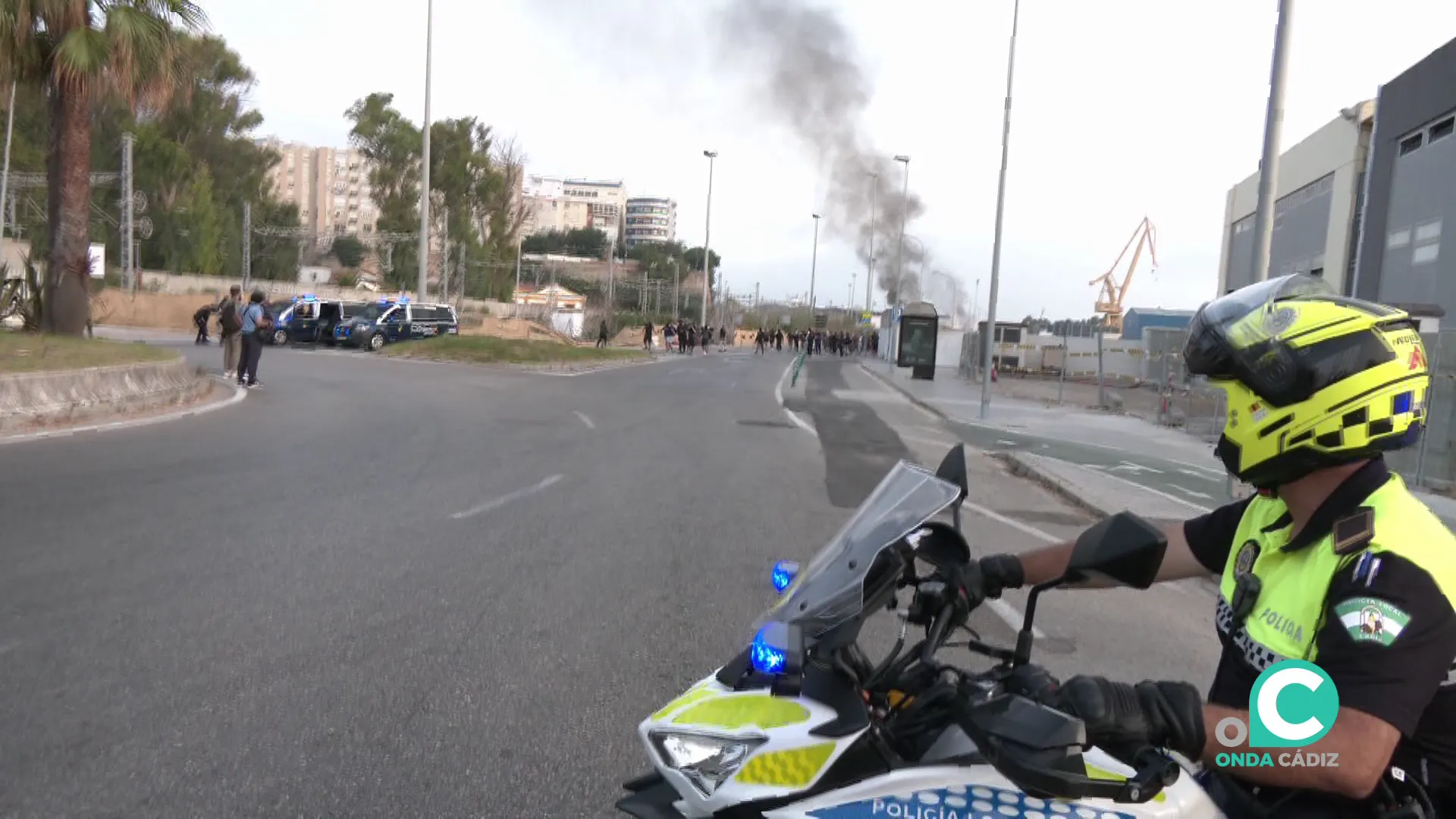 Un agente de Policía Local observan piquetes en la rotonda de la carretera industrial.