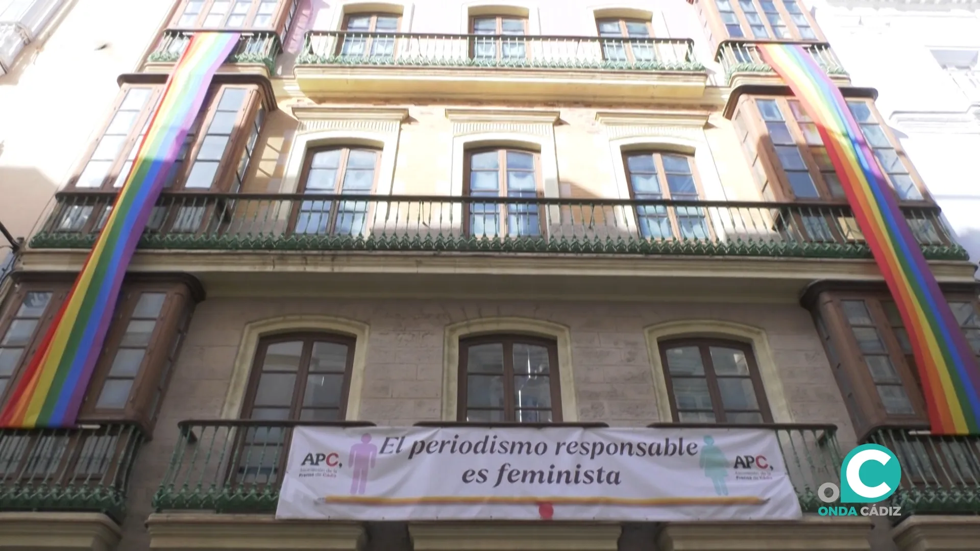 Dos banderas LGTBIQ+ lucen en la fachada de la APC.