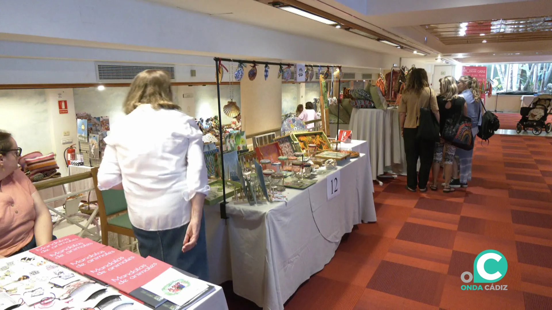 Mostradores con los productos dispuestos para fines benéficos en los salones del Hotel Playa Victoria