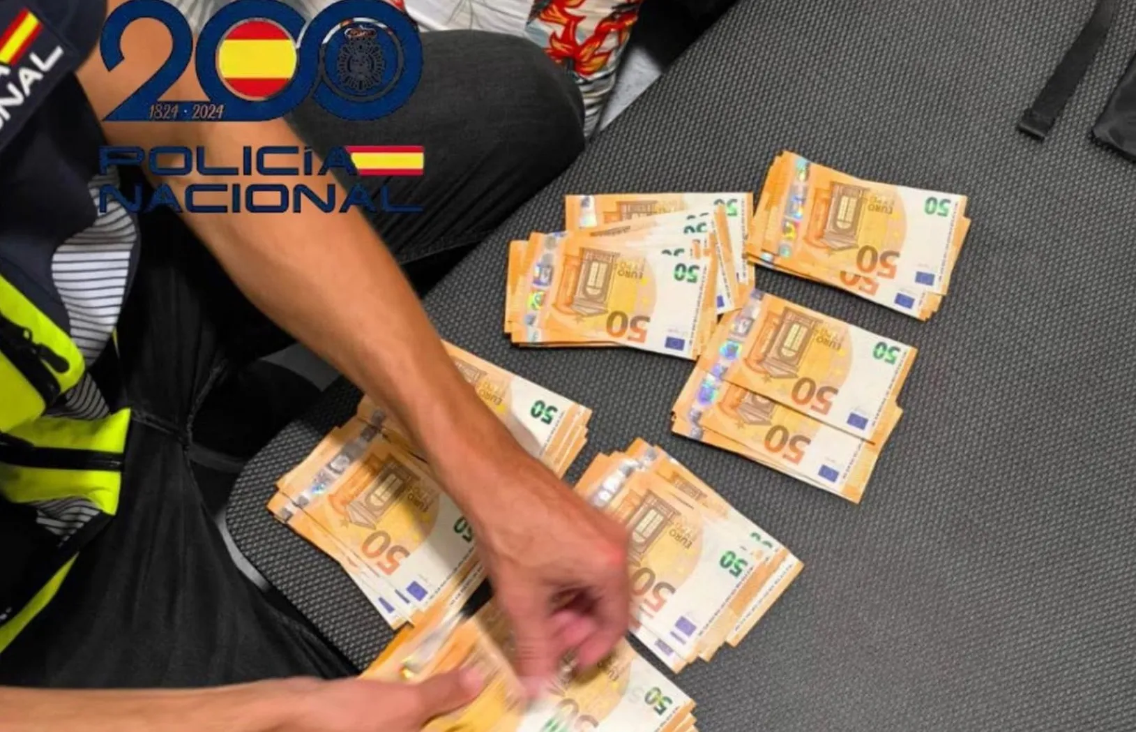 Un agente contando dinero incautado durante las acciones policiales