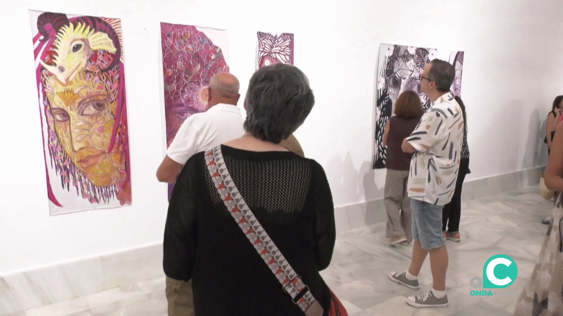 Visitantes en la jornada observan las obras durante la inauguración de la muestra