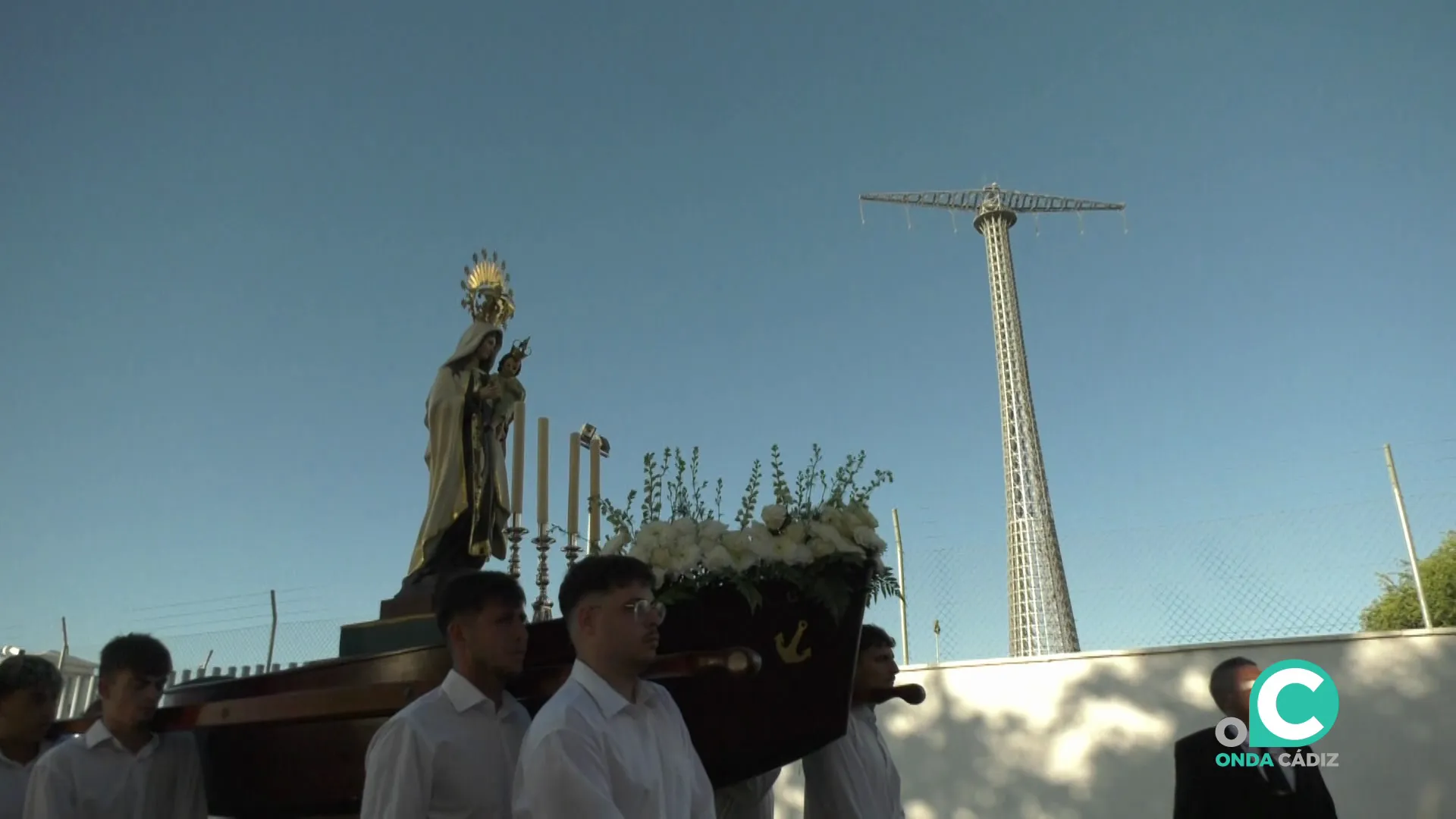 El cortejo durante su recorrido ante la iconíca imagen de una de las gigantéscas torres eléctricas