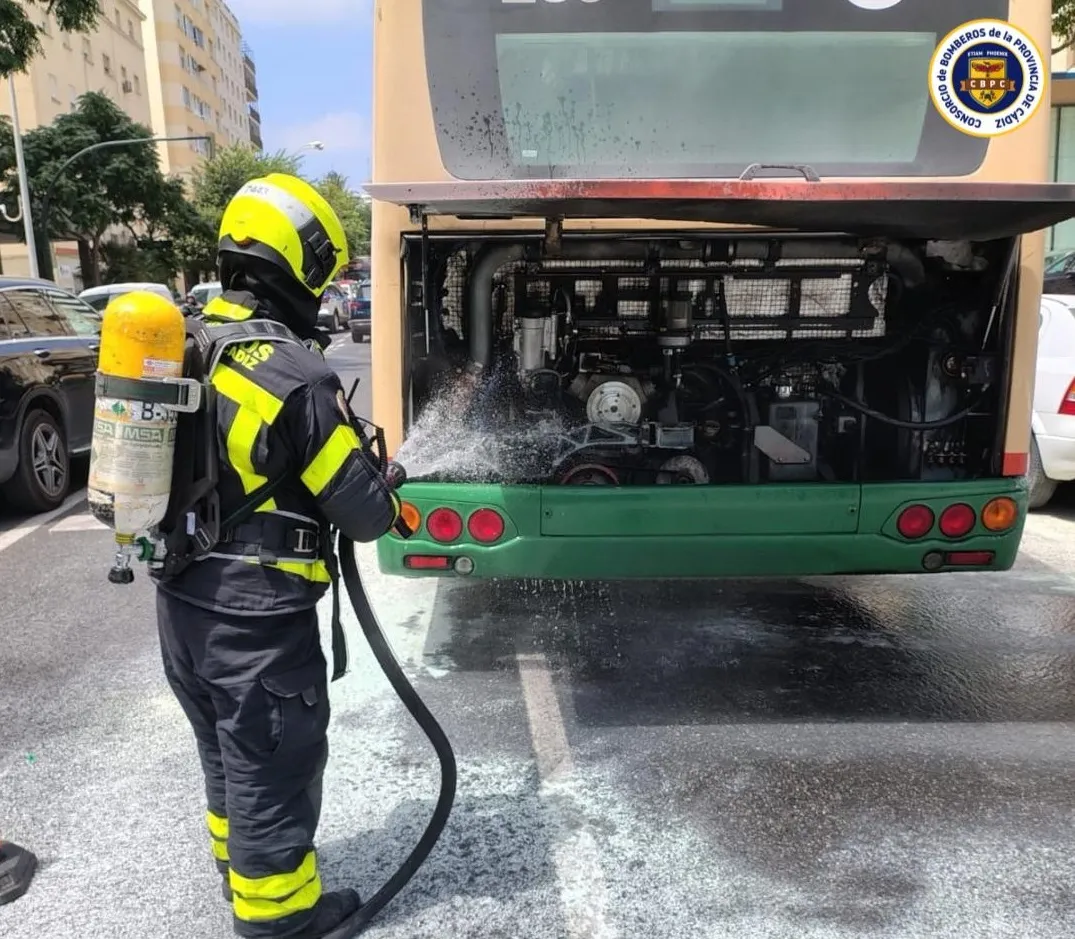 Bomberos sofocan el incendio originado en el motor del autobús urbano. 