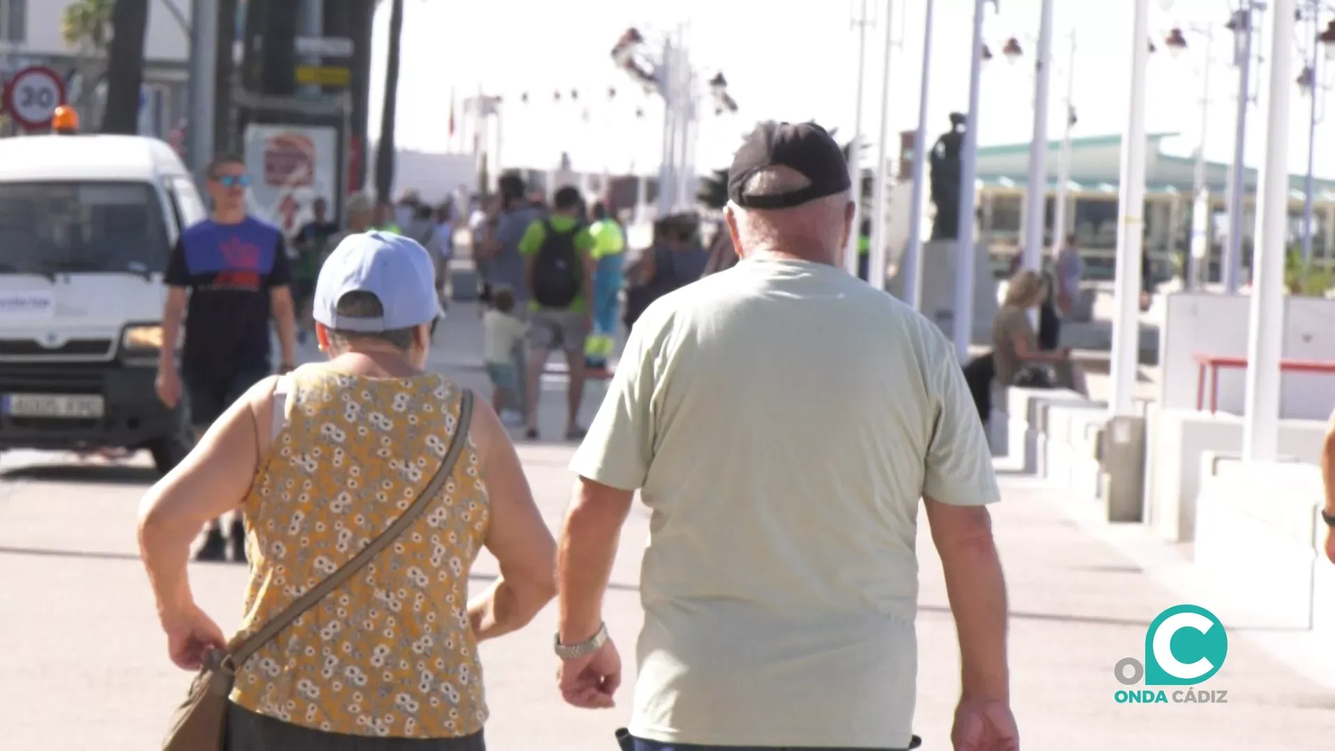 Viandantes paseando por el paseo marítimo de Cádiz. 