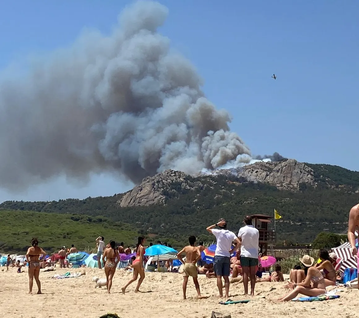 Unos bañistas observan la magnitud del siniestro en Tarifa el pasado lunes