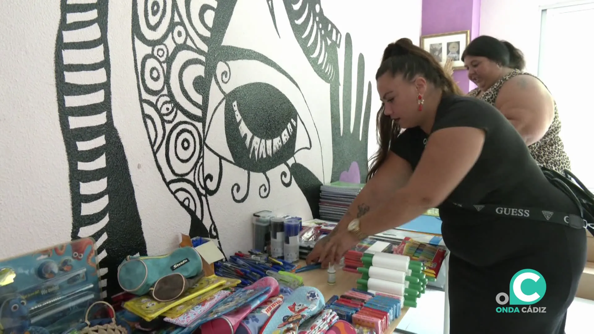 Miembros de la asociación clasificando el material escolar recogido