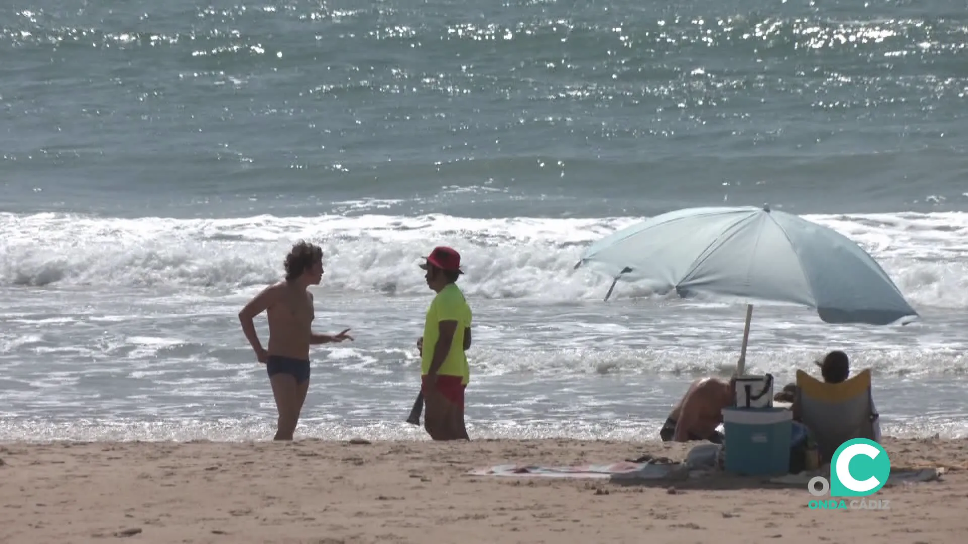 Un bañista habla con personal de salvamento en la capital gaditana