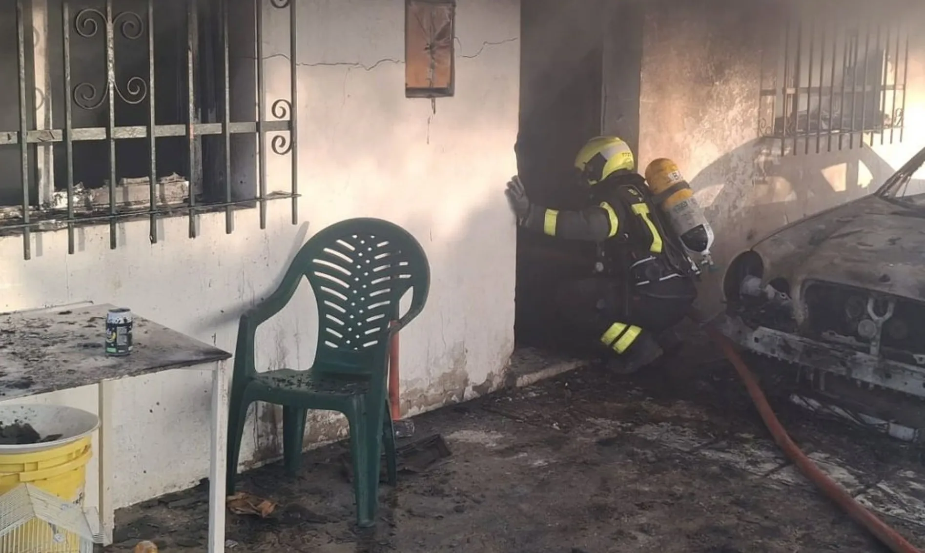 Un bombero actuando en la entrada del inmueble donde se produjo el siniestro