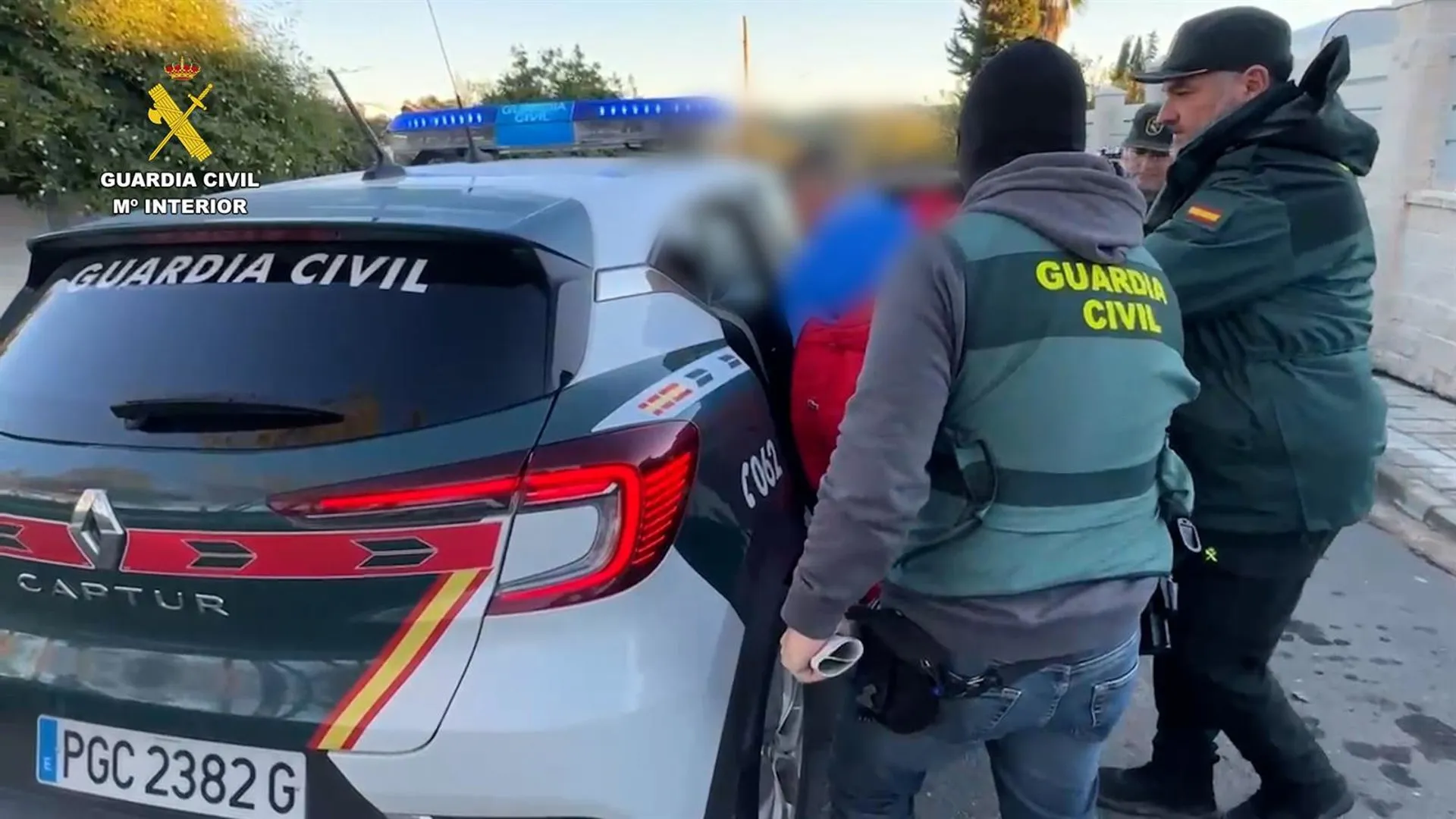 Agentes de la Guardia Civil introducen en el coche a uno de los arrestados