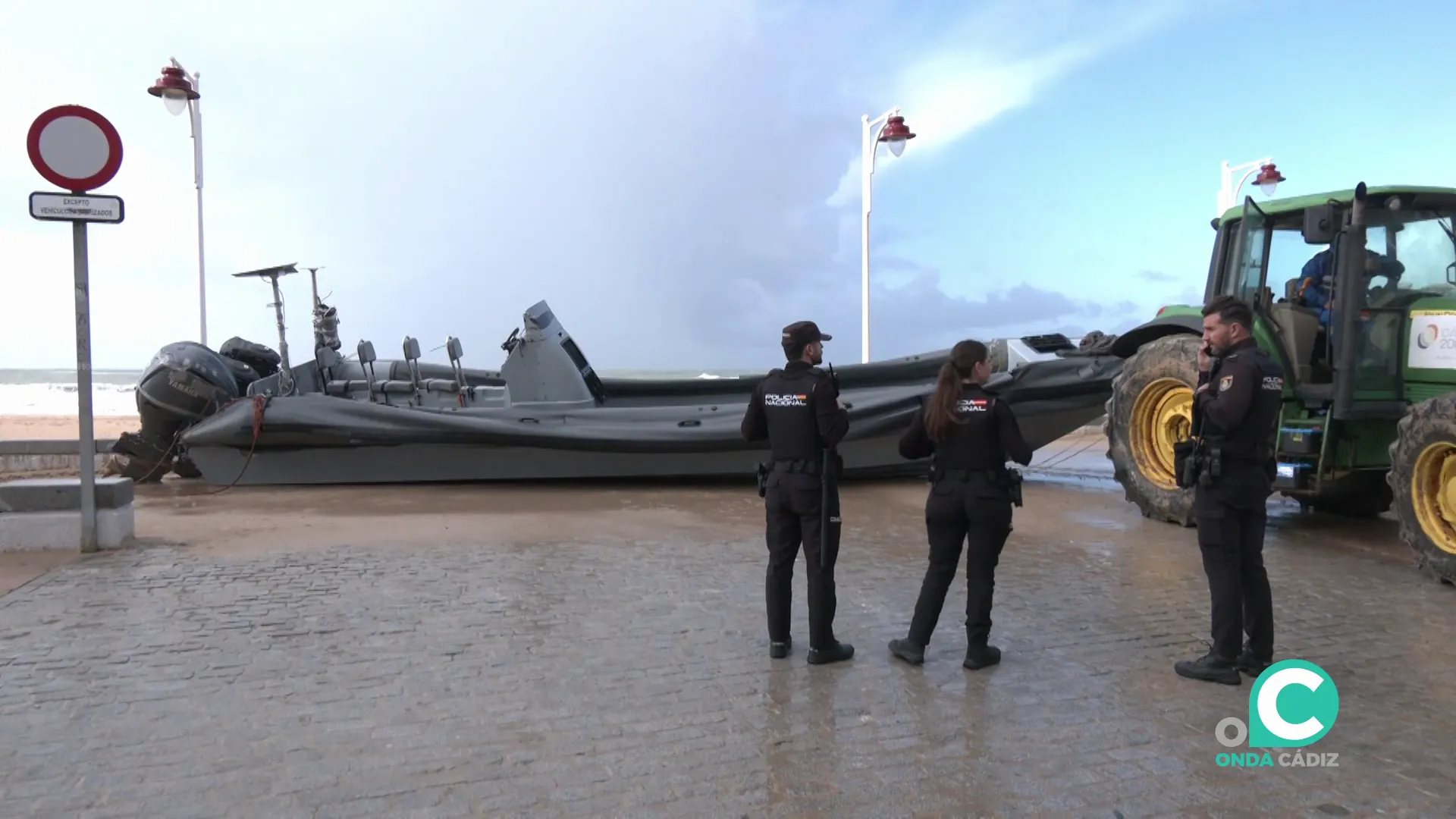 Agentes junto a la embarcación en su retirada en el paseo marítimo de la capital gaditana
