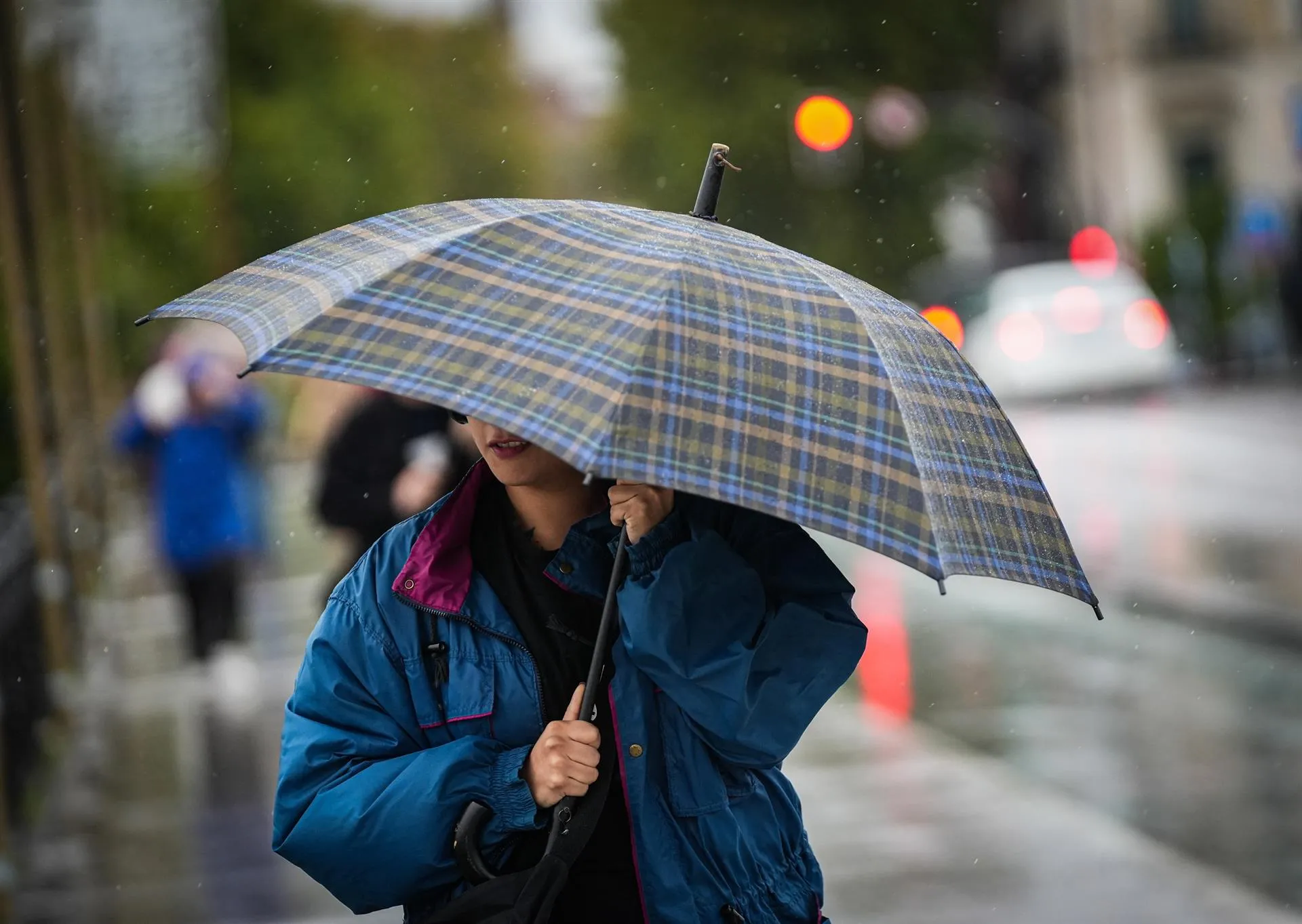 Una mujer intenta protegerse del mal tiempo con un paraguas