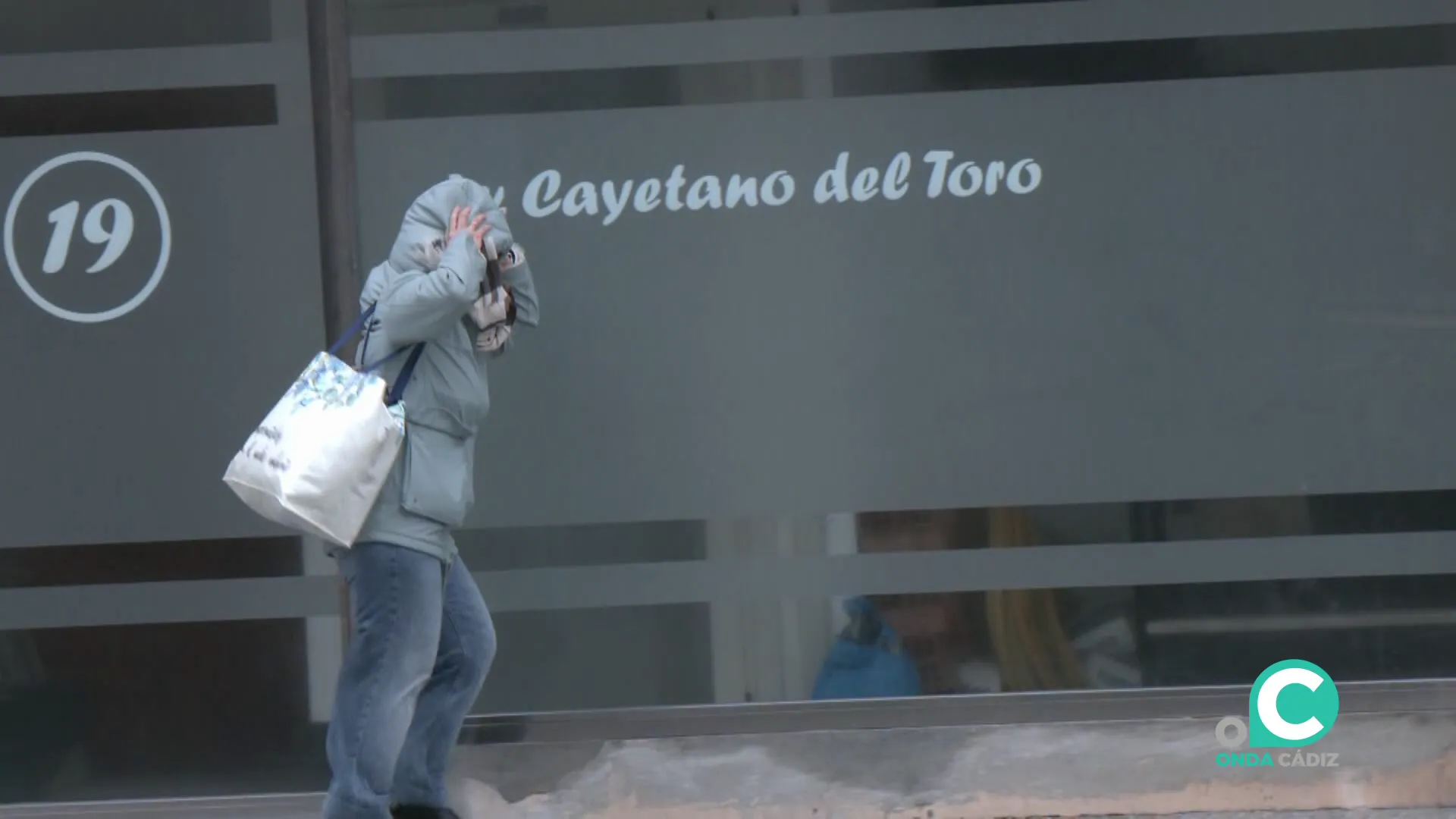 Una mujer se protege del fuerto viento en la mañana de este miércoles en la capital gaditana