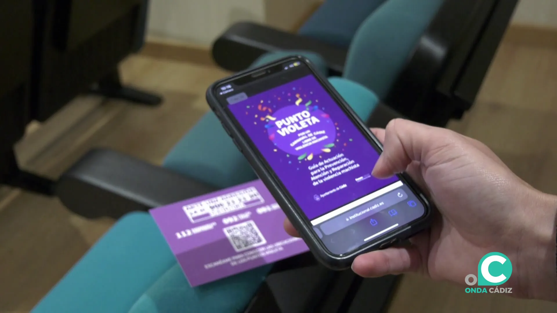 Pantalla de móvil con la aplicación de Punto Violeta que se puede acceder a través de un código QR.