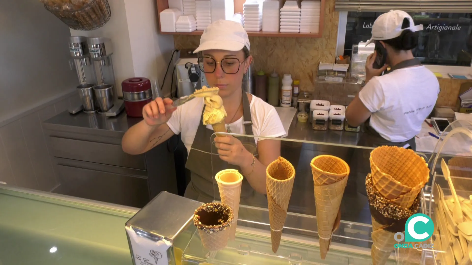 Una empleada del establecimiento prepara uno los productos para ser servidos a los clientes 