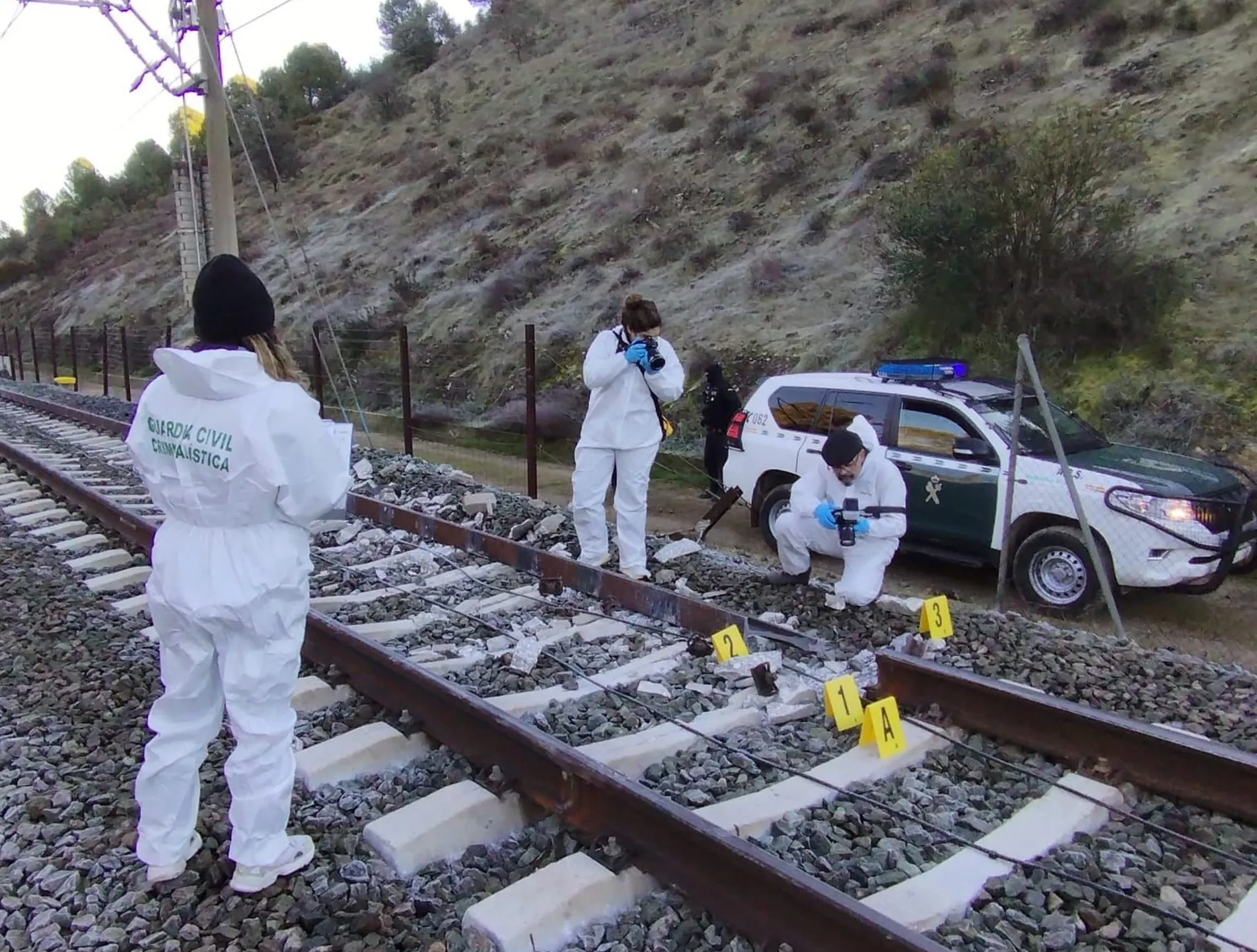 Agentes de la Guardia Civil inspeccionan un punto de rotura de la vía del tren 