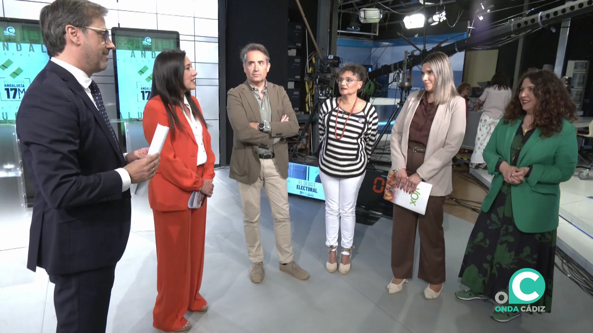 Algunos de los participantes dialogan poco antes del comienzo en los estudios de la televisión local