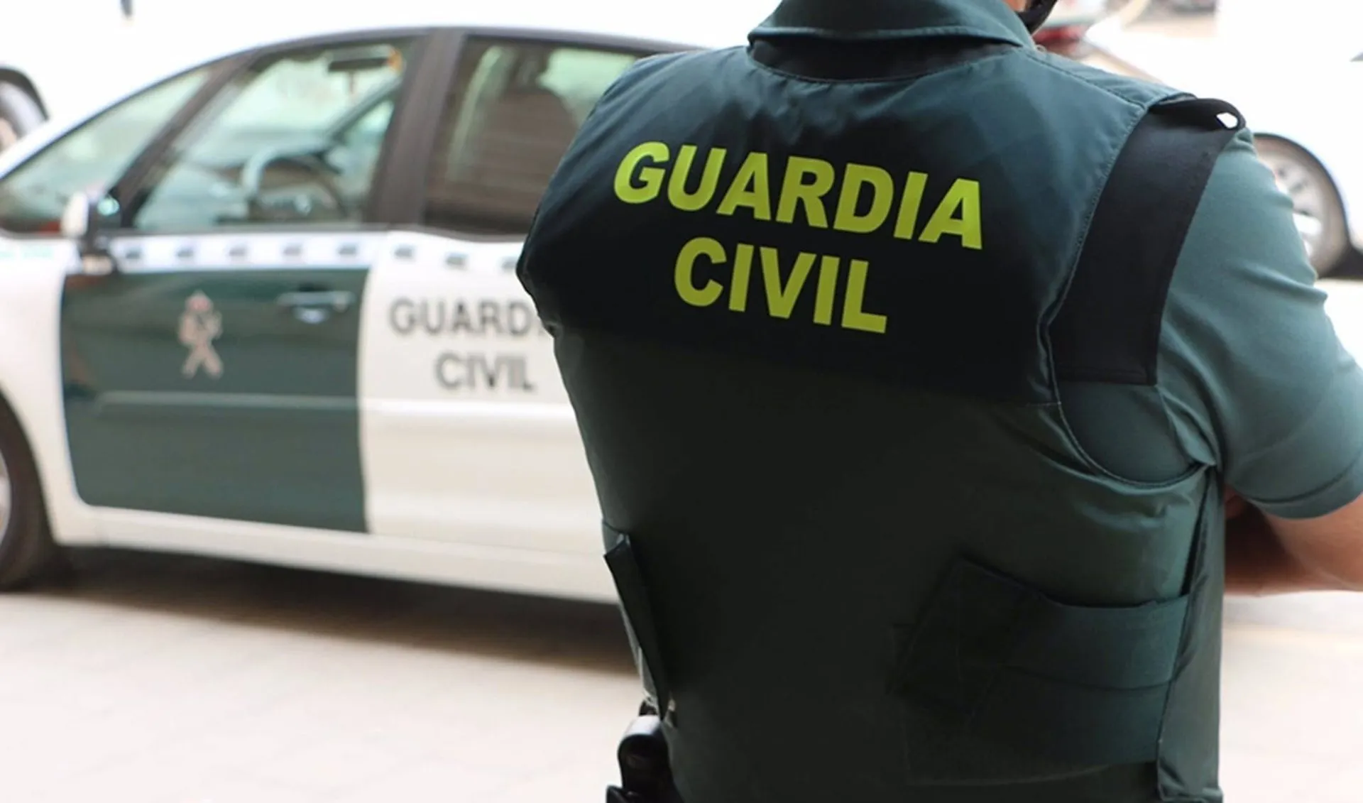 Imagen de archivo de un agente junto a un vehículo oficial.
