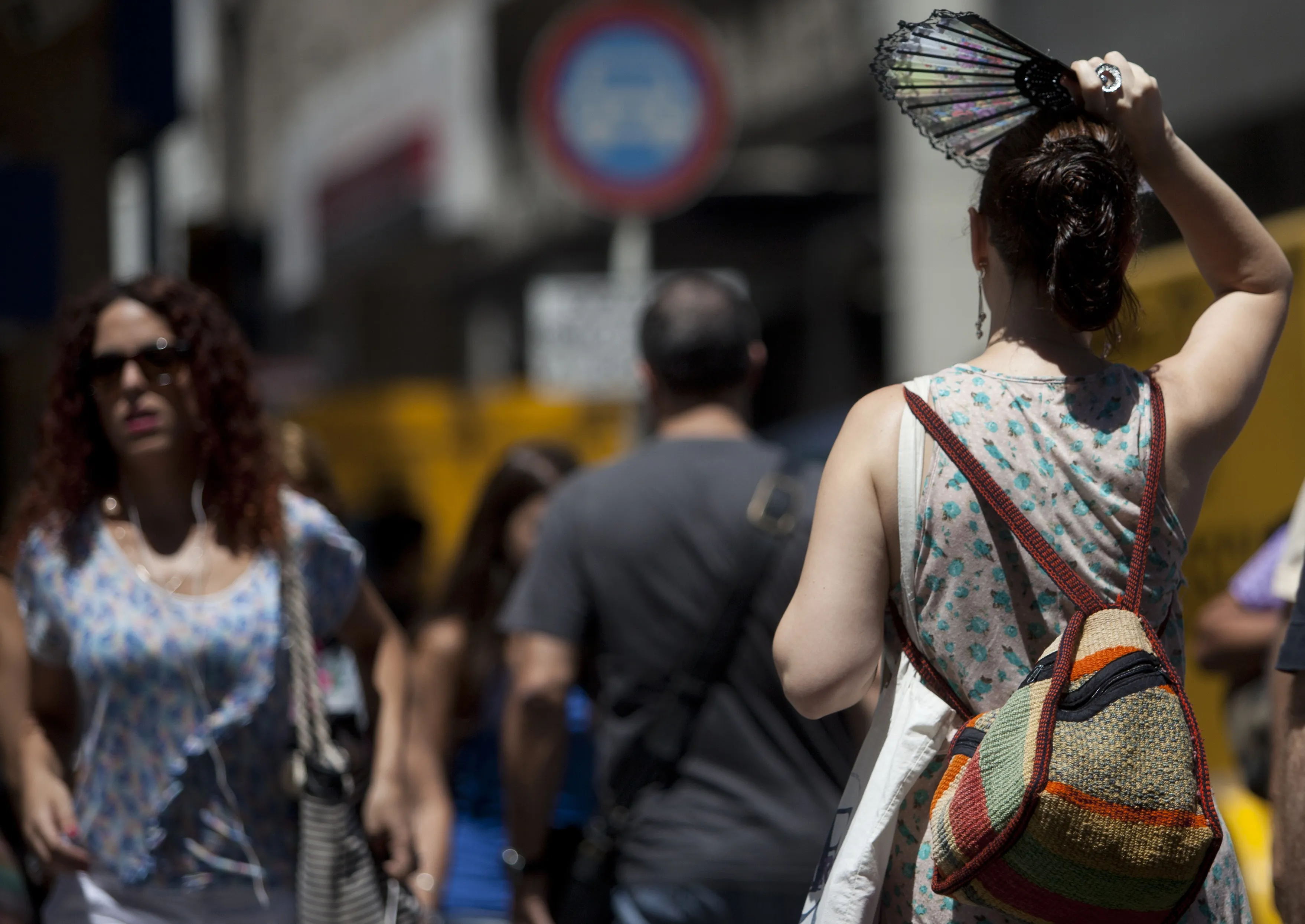 Viandantes protegiéndose del calor. 